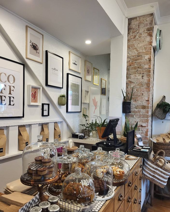 Les pâtisseries sous cloches de verre sur le comptoir carrelé, devant la colonne de briques
